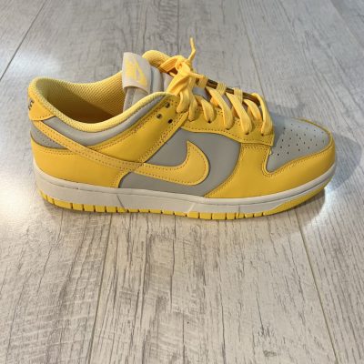 Vu de coté de la paire de Nike dunk low citron pulse. Une couleur jaune citron et blanche dominent la paire. Des lacets jaunes citron.