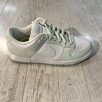 Vu de coté de la Nike dunk low next nature white mint. Une couleur vert pastel domine la paire avec du blanc. Des lacets couleur pastel.
