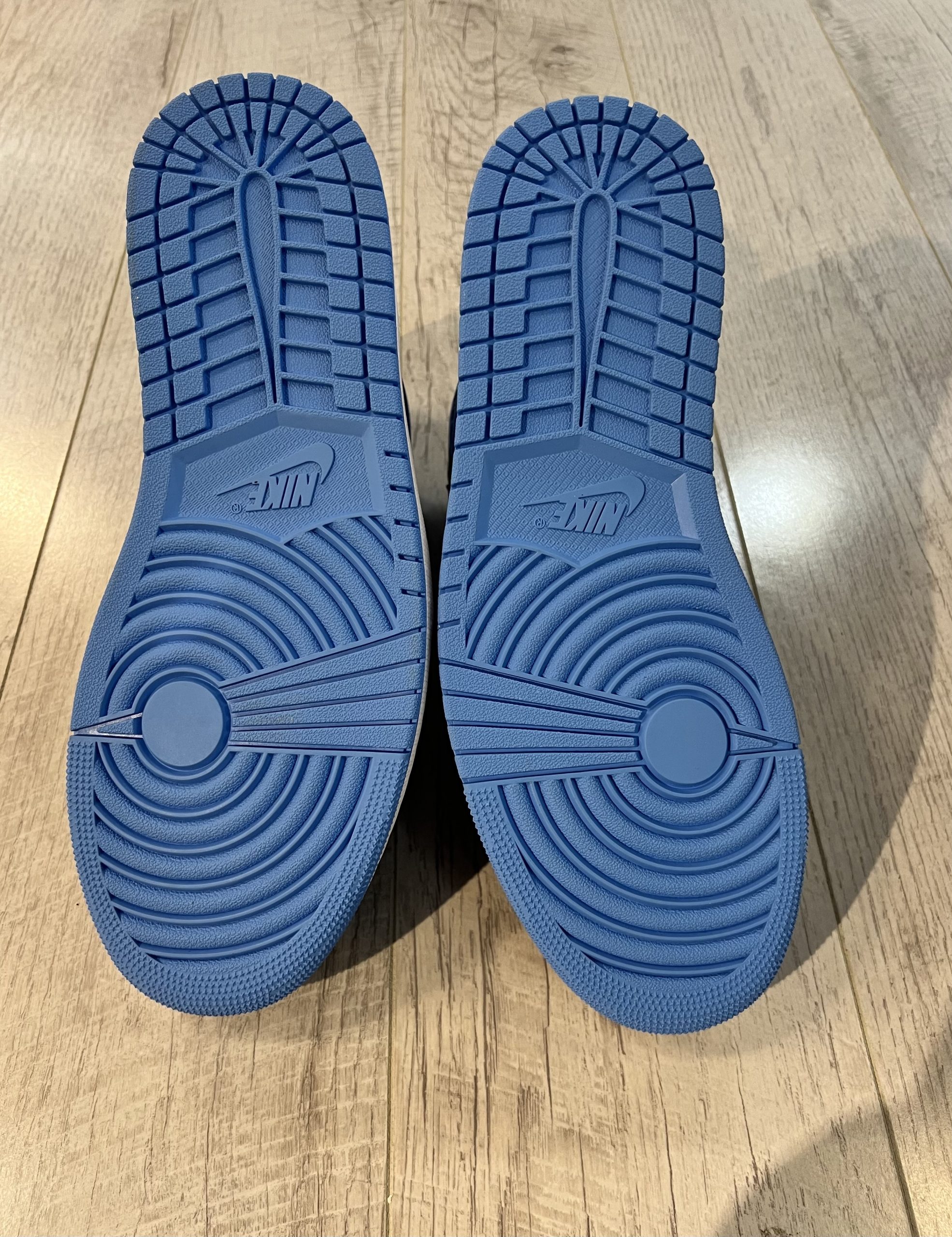 nike-air-jordan-1-high-og-university-blue-unc-toe.jpeg Vu du dessous de la Nike Air Jordan 1 High OG University Blue UNC Toe. Du bleu domine la semelle de la paire.