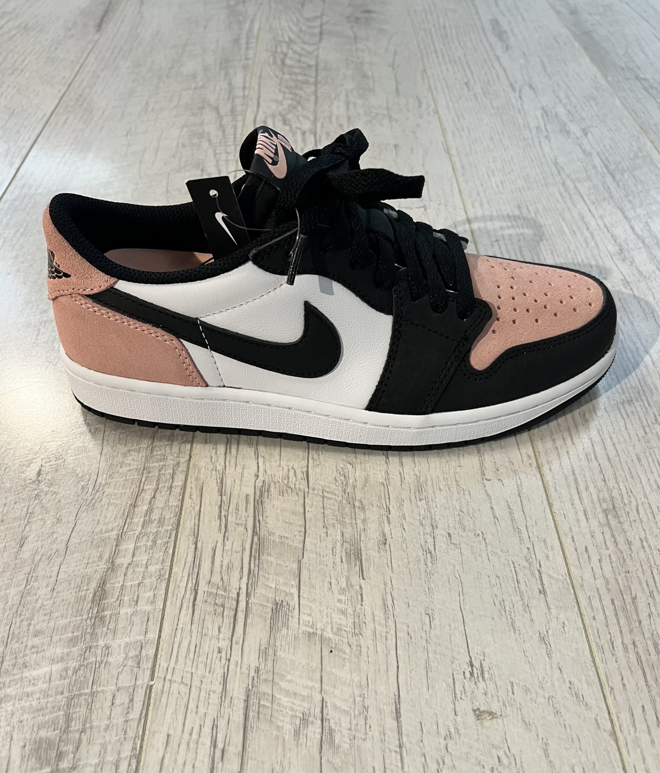 nike-air-jordan-1-low-og-bleached-coral.jpeg Vu de coté de la Nike Air Jordan 1 Low OG Bleached Coral. Du noir domine la paire ainsi qu'un rose pastel en daim. Du blanc complète la paire.