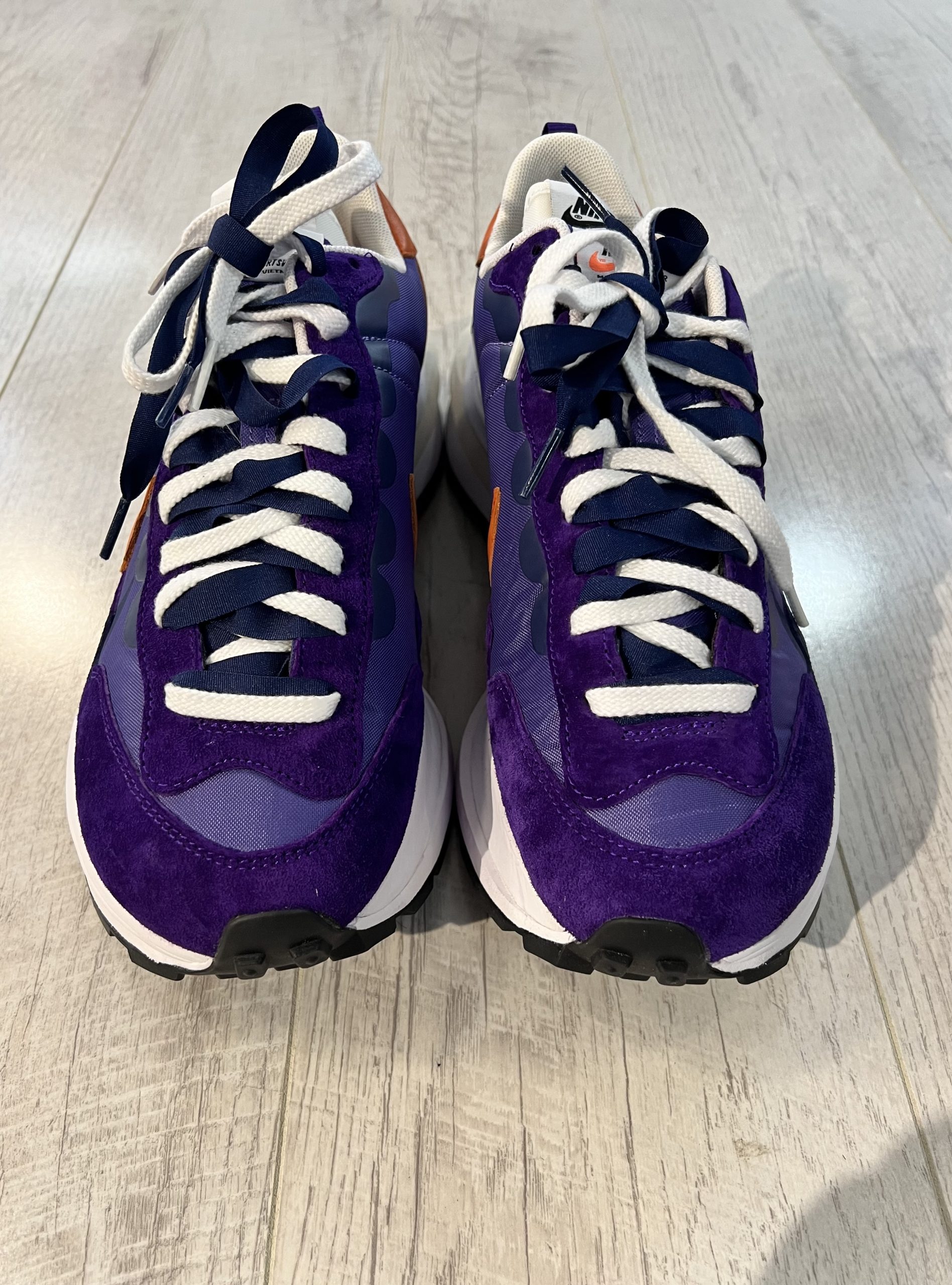 nike-sacai-vaporwaffle-dark-iris Vu du dessus de la Nike Sacai VaporWaffle Dark Iris. Un violet foncé et plus clair dominent en matière en daim. Une semelle blanche? Des lacets de couleur bleu foncé et blanc.