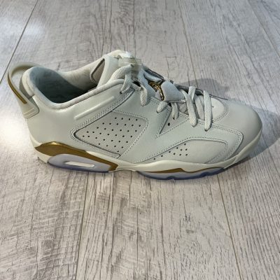 Vu de coté de la paire de Nike Air Jordan 6 Low Chinese New Year 2022. Un blanc couleur crème, des lacets blancs et du or sur le talon. Une matière en cuire.
