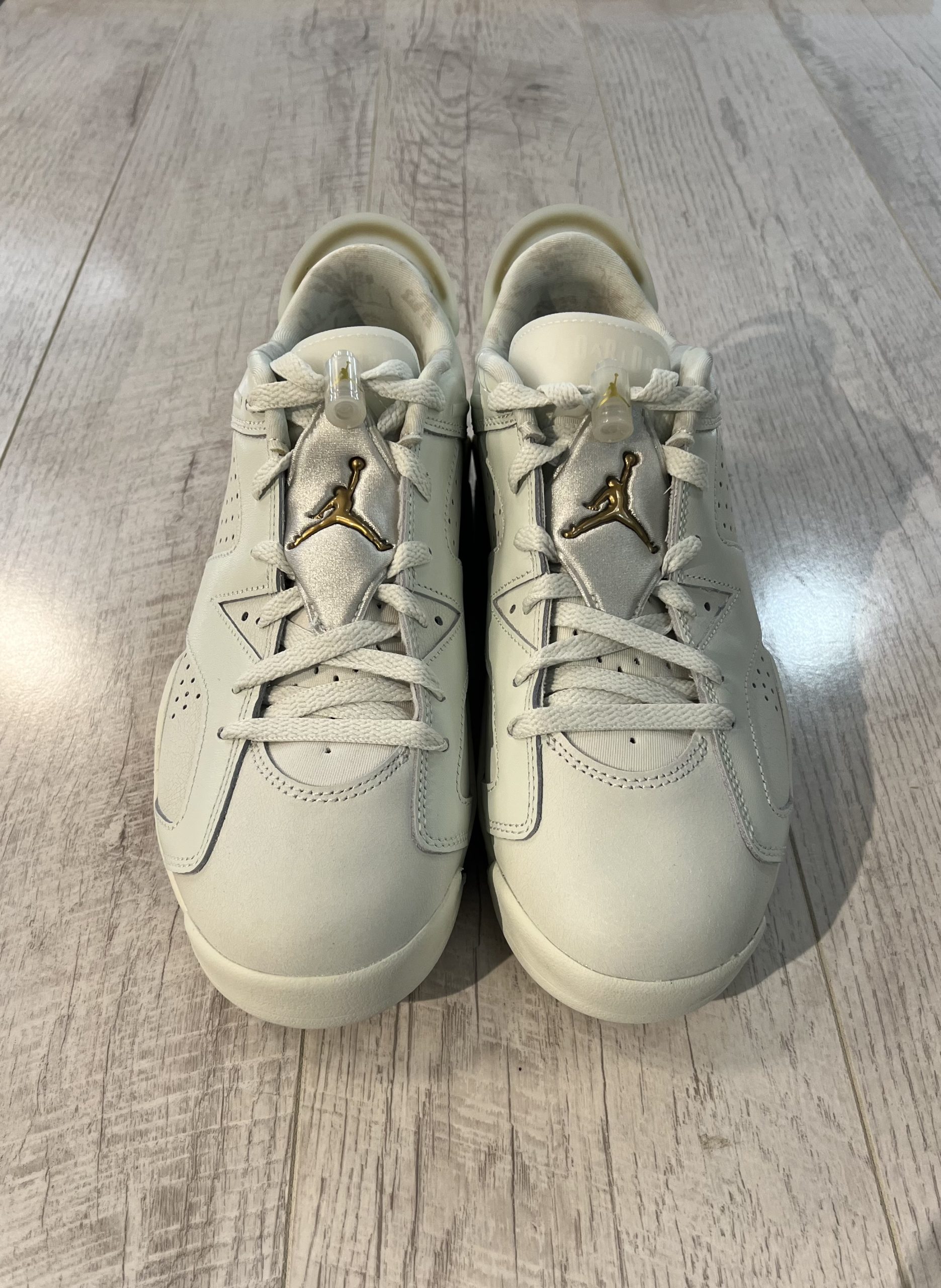 nike-air-jordan-6-low-chinese-new-year-2022.jpeg Vu de coté de la paire de Nike Air Jordan 6 Low Chinese New Year 2022. Un blanc couleur crème, des lacets blancs et du or sur le talon. Un logo Jordan doré sur la languette. Une matière en cuire.